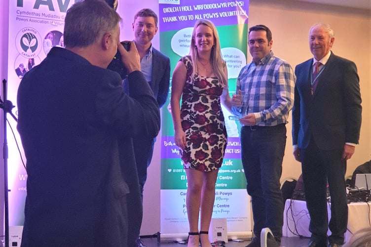 Talgarth Town FC Juniors – Robbie Hardy receives the Group Volunteering Award from PAVO Interim Chief Executive, Clair Swales, as PAVO Chair Jamie Burt and Tom Jones OBE, High Sheriff of Powys, look on.