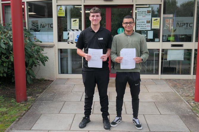 Callum Williams (left) and James Vaughan (right) hold up their results slips for Uniformed Protective Services.