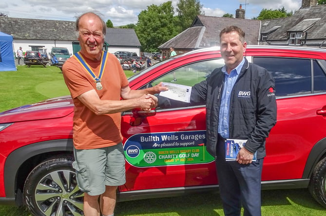 Builth Wells Rotary President, Robert Evans receiving a cheque from Tim Evans of Builth Wells Garages, on behalf of himself and brother Martyn