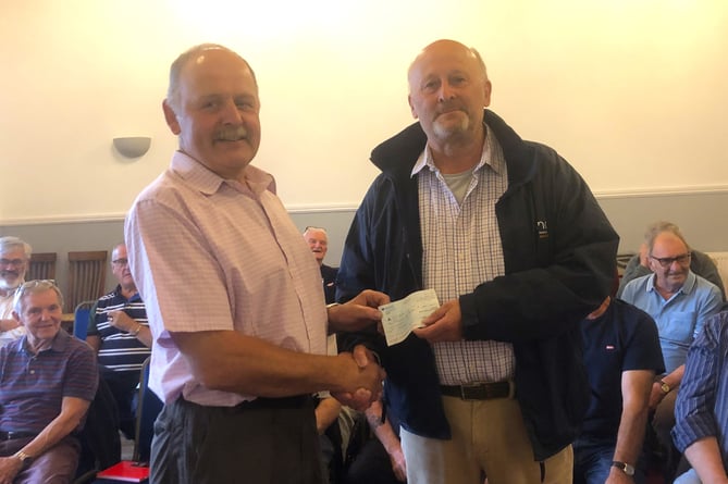 Chairman of Builth Male Voice Choir, Ian Coldrick presenting the cheque for £1,000 to Richard Shackelford of the Motor Neurone Disease Association