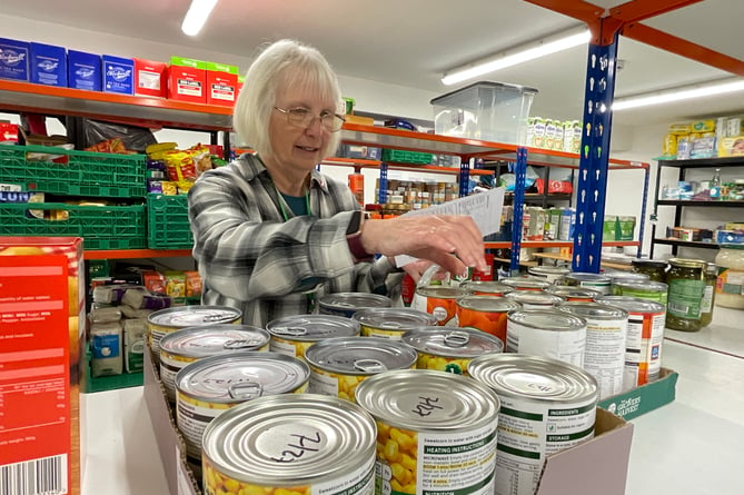 Tessa Bradley, Llandrindod Foodbank and Advice Centre Project Manager picking a food parcel.