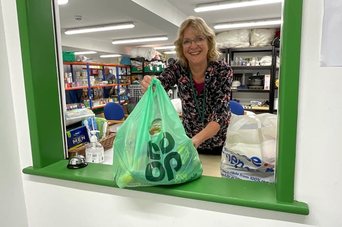 A volunteer handing out a food parcel at Llandrindod Foodbank.