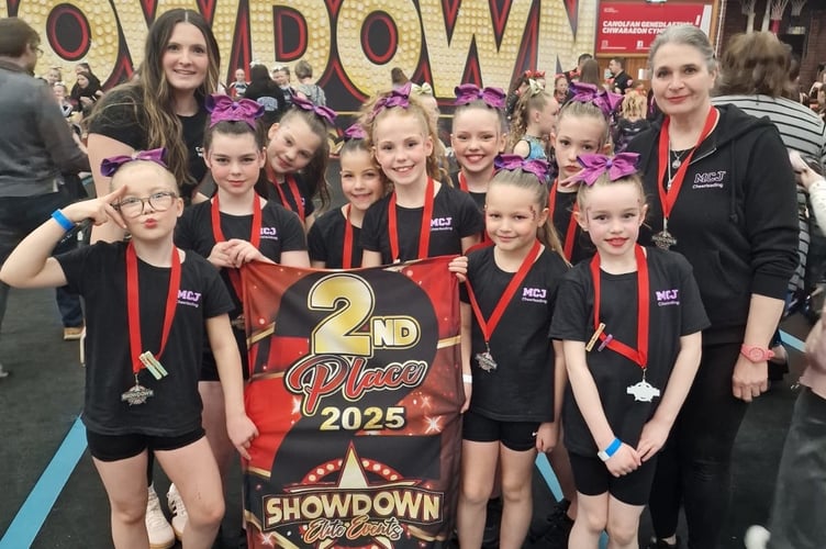 The cheerleading team pictured with MCJ Cheerleading founder and coach, Millie Jones (left) and her mum 'Coach Pammy' (right)